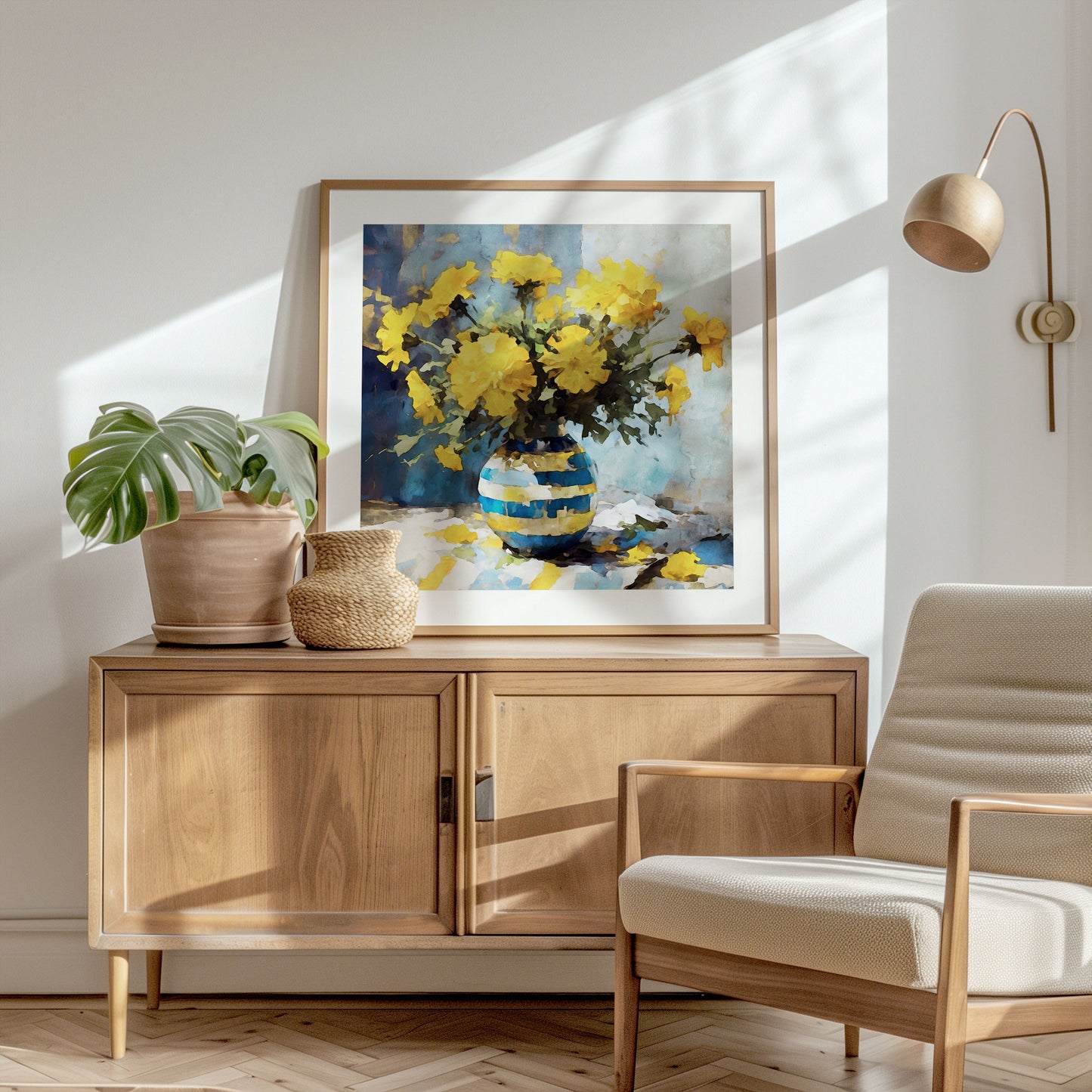 Square format watercolor painting of yellow marigolds in a blue striped vase, showcased in a light-filled room alongside a potted plant and woven basket on a wooden cabinet.