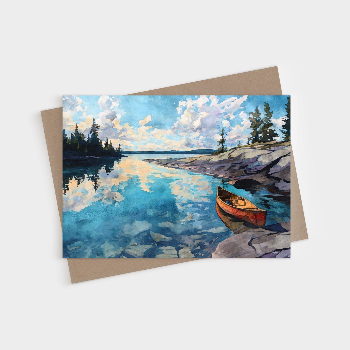 Watercolor greeting card featuring a serene lake scene with a red canoe resting on rocky shore. The calm blue water reflects fluffy clouds and pine trees along the horizon, capturing a peaceful wilderness atmosphere.