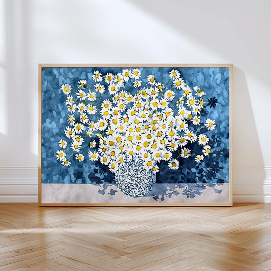 Framed artwork of a bouquet of white daisies with yellow centers in a patterned vase, set against a textured deep blue background. The print rests on a light wood herringbone floor, leaning against a white wall in natural sunlight.