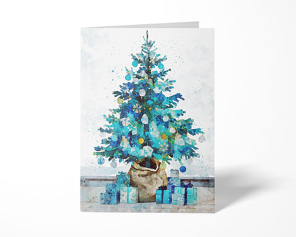 Folded Christmas card featuring a watercolor-style blue and teal tree decorated with ornaments, set in a burlap-wrapped pot with matching blue presents at its base against a soft white background.