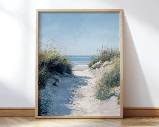 Framed coastal landscape art print featuring a sandy path through tall beach grass leading to a calm blue ocean under a clear sky, styled in soft watercolor tones.