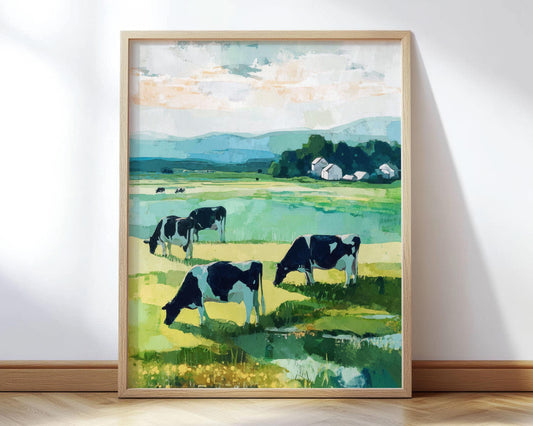 Framed painting of a pastoral countryside scene with black and white cows grazing in a green meadow. In the distance, a cluster of white farm buildings sits near a line of trees, with rolling blue hills under a partly cloudy sky. The artwork uses bold, painterly brushstrokes in greens, blues, and warm neutrals for a serene, modern impressionist look.