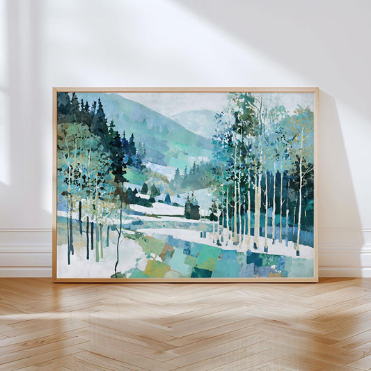 Framed painting of a serene mountain landscape with snow, pine trees, and birch trees in shades of blue, green, and white. The artwork features a geometric, patchwork effect at the base and soft gradients in the hills, creating a modern impressionist style. Displayed in a light wood frame and leaning against a white wall on a polished wood floor with sunlight streaming in.